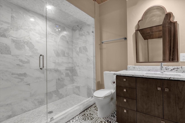 bathroom with vanity, toilet, tile floors, and a shower with shower door