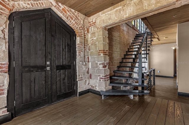 entrance foyer with wooden ceiling, brick wall, and hardwood / wood-style flooring