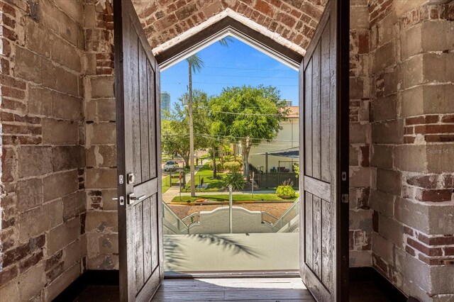 doorway with dark hardwood / wood-style floors and lofted ceiling