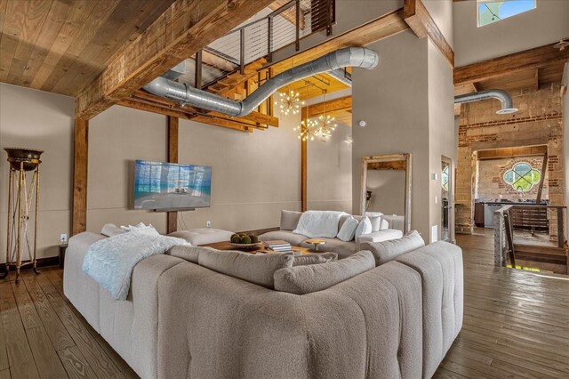 living room with a towering ceiling, dark hardwood / wood-style flooring, and a chandelier