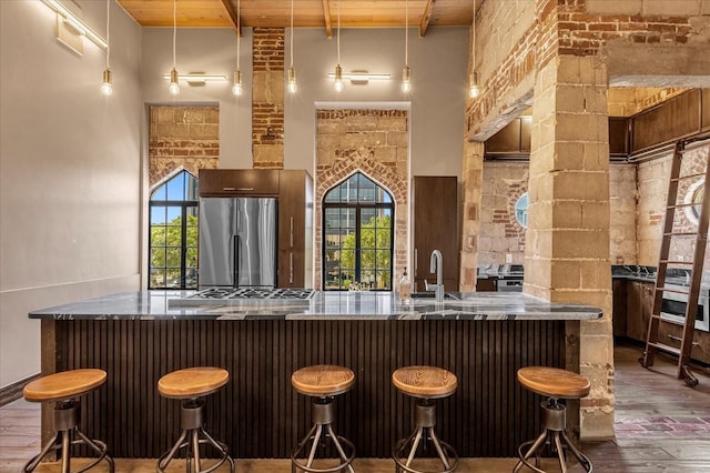 bar featuring wooden ceiling, hardwood / wood-style floors, a towering ceiling, and stainless steel fridge