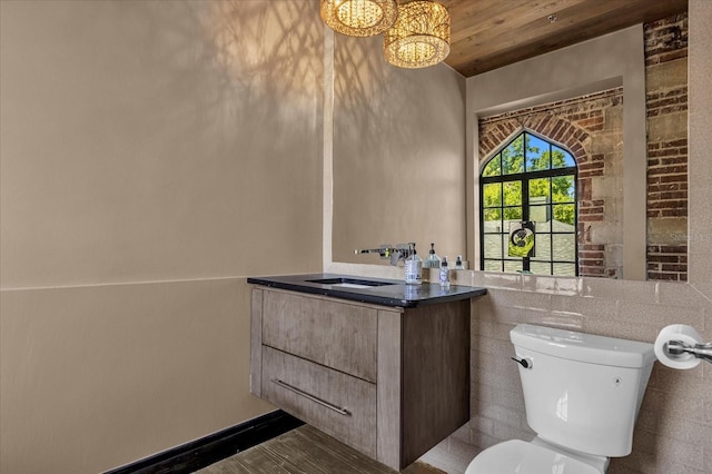 bathroom featuring vanity with extensive cabinet space, tile walls, wood ceiling, a chandelier, and toilet