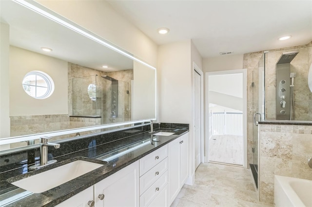 bathroom with tile walls, independent shower and bath, and vanity