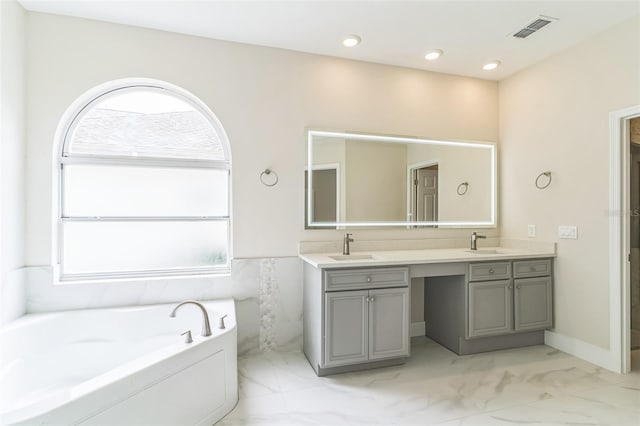 bathroom with a tub and vanity