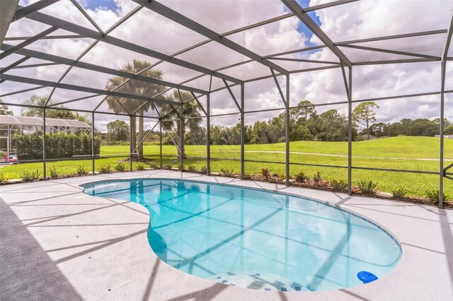 view of swimming pool with glass enclosure, a lawn, and a patio