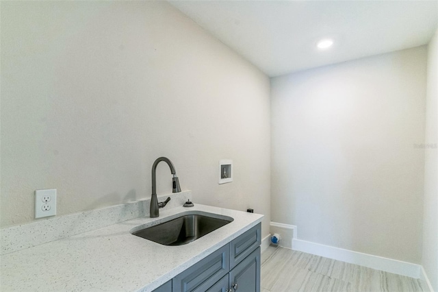 clothes washing area featuring hookup for a washing machine, cabinets, and sink