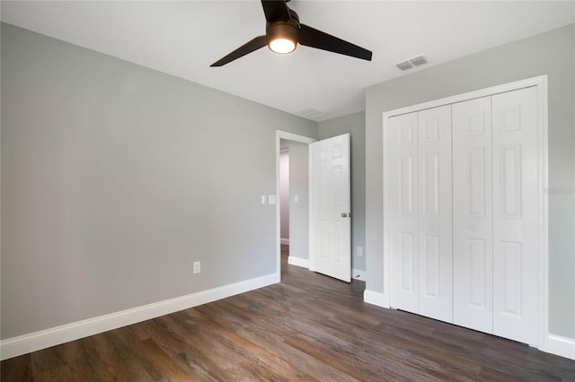 unfurnished bedroom with ceiling fan, dark wood-type flooring, and a closet