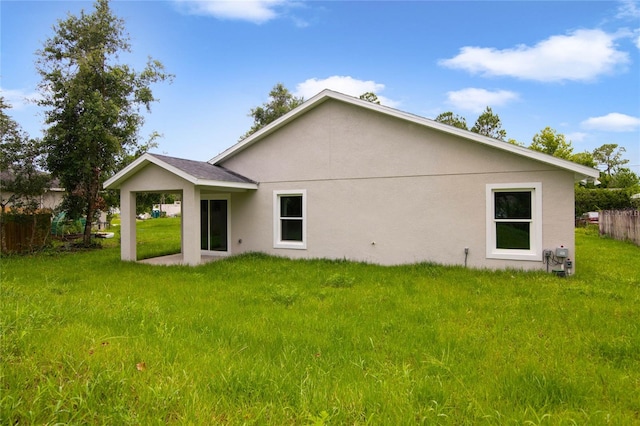 rear view of house featuring a lawn and a patio area