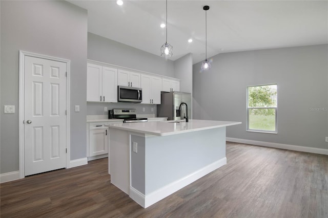 kitchen featuring stainless steel appliances, decorative light fixtures, a center island with sink, white cabinetry, and lofted ceiling