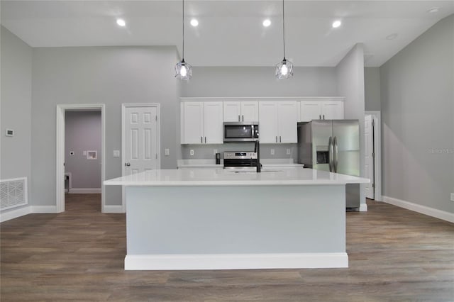 kitchen featuring white cabinets, pendant lighting, and stainless steel appliances