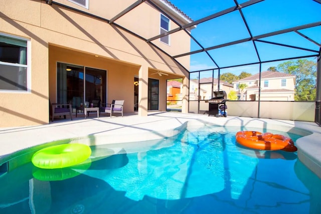 view of swimming pool featuring a patio area, a grill, and a lanai