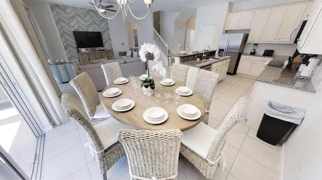 dining area featuring sink, a chandelier, and light tile flooring