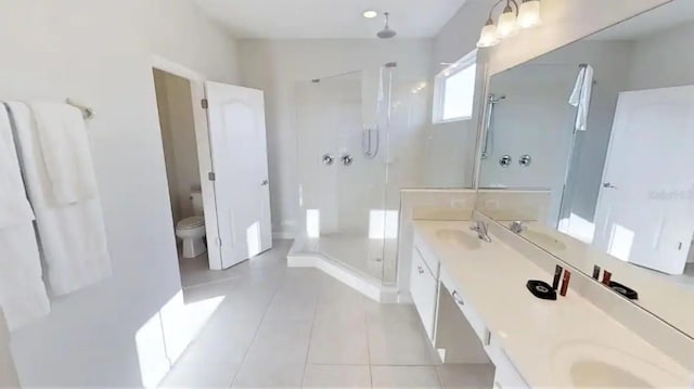 bathroom with tile flooring, toilet, double vanity, and an enclosed shower