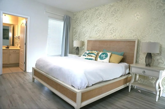 bedroom featuring connected bathroom and dark hardwood / wood-style flooring