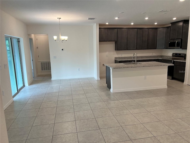 kitchen with light stone countertops, sink, black electric range oven, a notable chandelier, and an island with sink