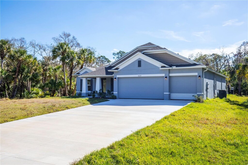 view of front of property with a garage, a front yard, and central air condition unit