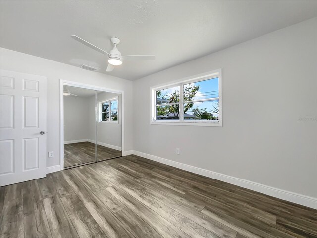 unfurnished bedroom featuring wood-type flooring, ceiling fan, and a closet