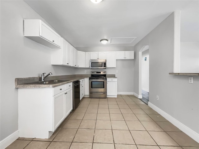 kitchen with white cabinetry, stainless steel appliances, light tile patterned flooring, and sink