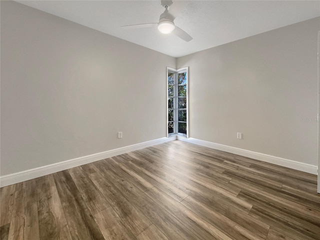 empty room featuring dark wood-type flooring and ceiling fan