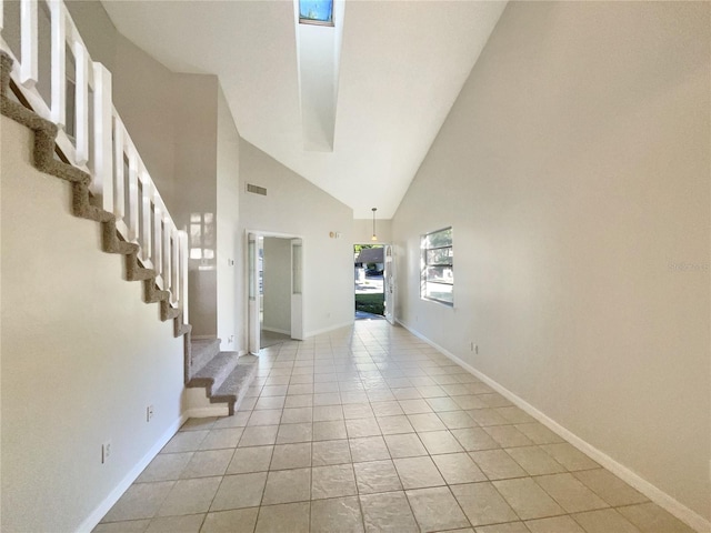 foyer featuring high vaulted ceiling and light tile flooring