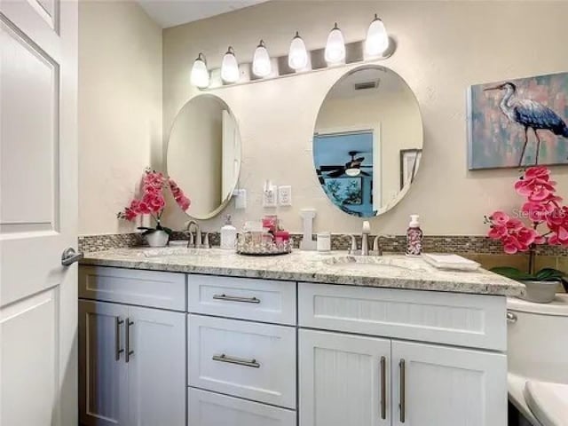 full bath featuring double vanity, a sink, and visible vents