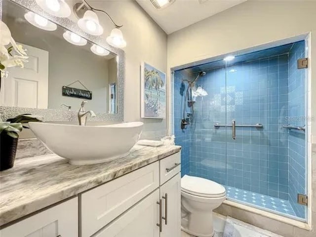 full bathroom with toilet, vanity, and a shower stall