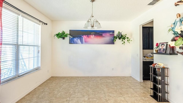 dining room featuring a chandelier and a textured ceiling