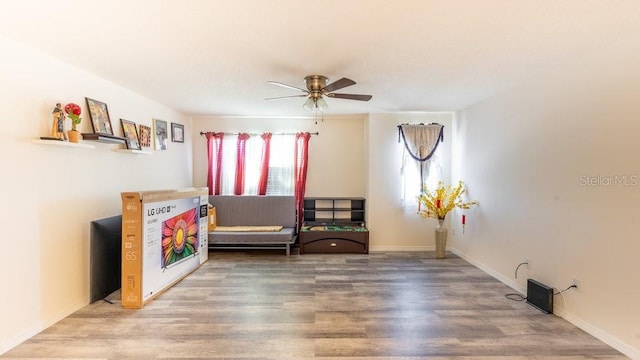 living area featuring hardwood / wood-style floors and ceiling fan