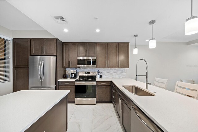 kitchen with stainless steel appliances, hanging light fixtures, decorative backsplash, sink, and light tile patterned floors