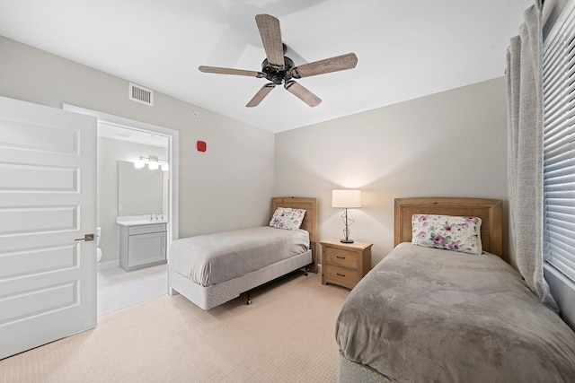 carpeted bedroom featuring ensuite bath and ceiling fan