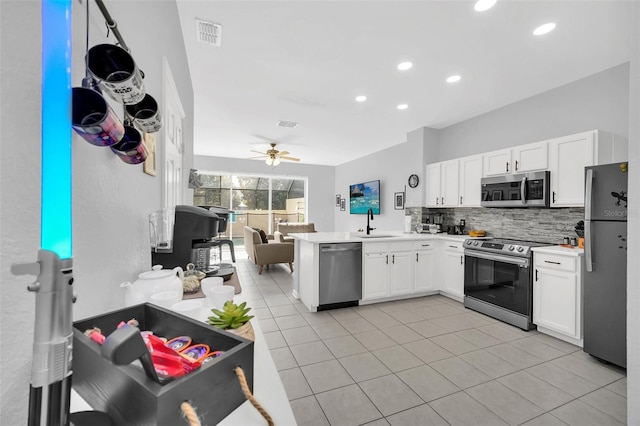 kitchen featuring backsplash, appliances with stainless steel finishes, white cabinetry, ceiling fan, and sink