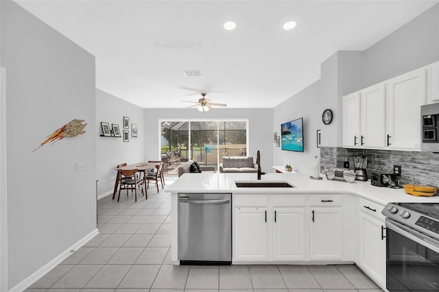 kitchen featuring light tile flooring, ceiling fan, stainless steel appliances, kitchen peninsula, and white cabinetry