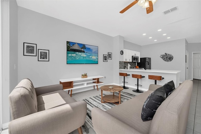 living room featuring ceiling fan and light tile flooring