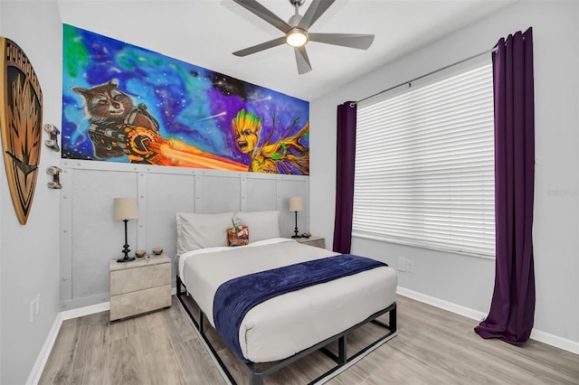 bedroom with ceiling fan, light wood-type flooring, and multiple windows