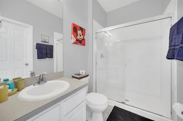 bathroom featuring tile flooring, toilet, vanity, and a shower with door