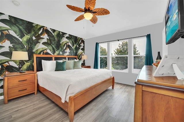 bedroom with light hardwood / wood-style floors and ceiling fan