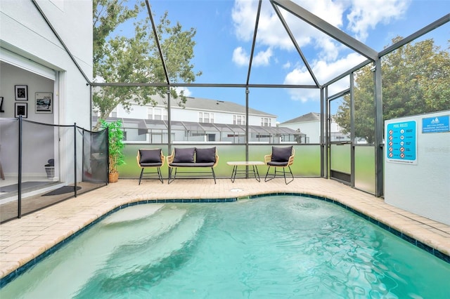 view of swimming pool featuring a lanai