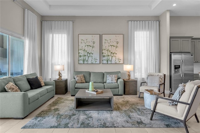 tiled living room with a healthy amount of sunlight and a raised ceiling