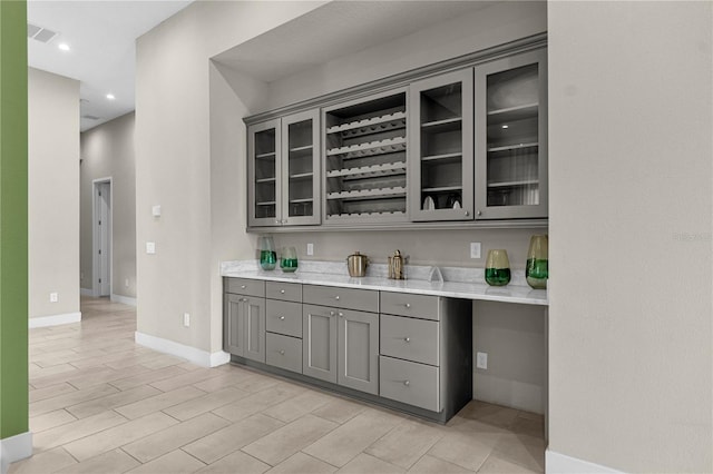 bar with light tile flooring and gray cabinetry