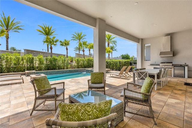 view of patio featuring exterior kitchen and a fenced in pool