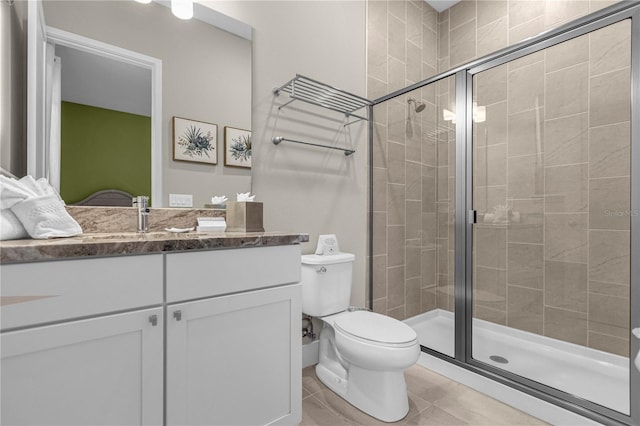 bathroom featuring an enclosed shower, vanity, toilet, and tile flooring