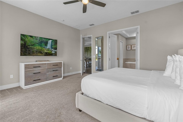 bedroom featuring light colored carpet, ceiling fan, and ensuite bathroom