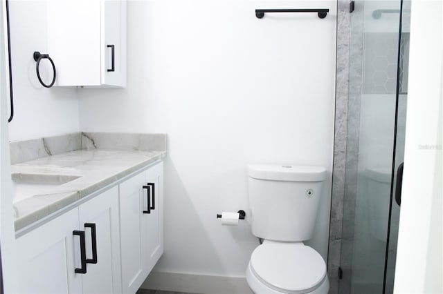 bathroom featuring toilet, vanity, and walk in shower