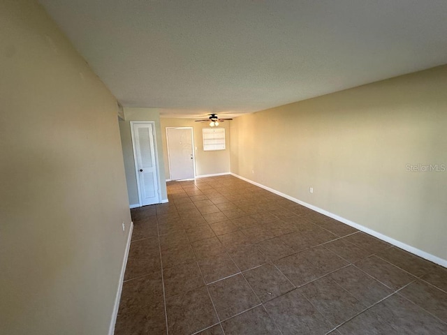 tiled empty room featuring ceiling fan