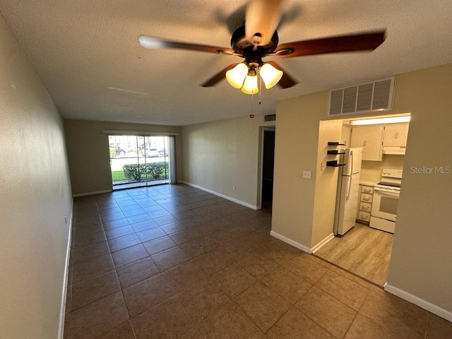 tiled empty room with a textured ceiling and ceiling fan