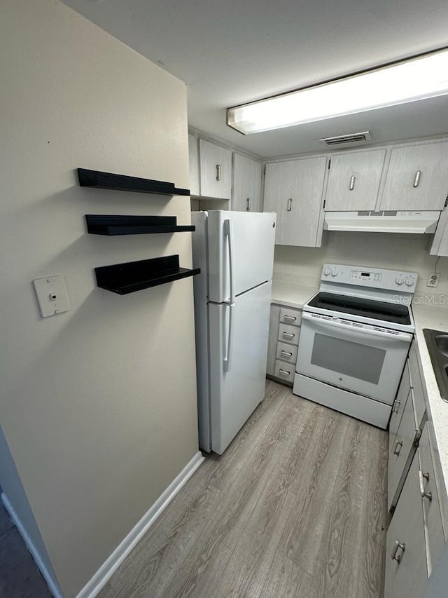 kitchen with light hardwood / wood-style flooring, sink, and white appliances