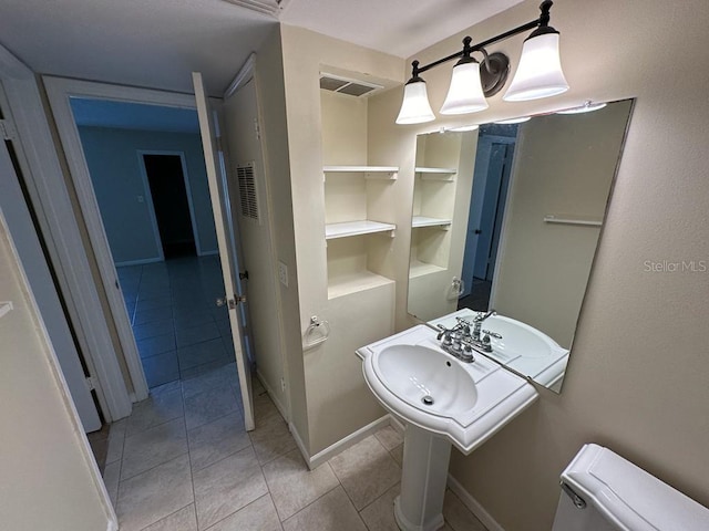 bathroom with tile flooring, toilet, and built in features