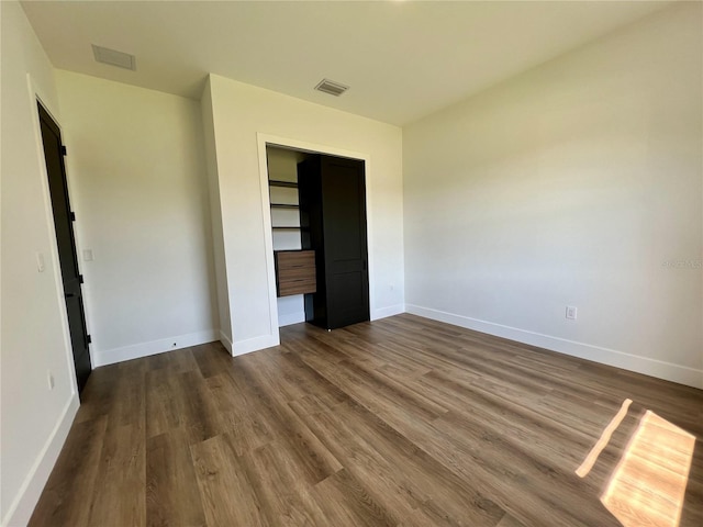 unfurnished bedroom featuring dark hardwood / wood-style flooring and a closet