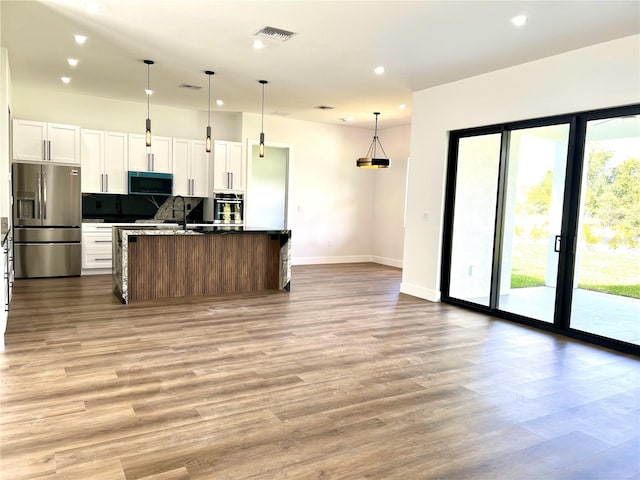 kitchen with a wealth of natural light, stainless steel appliances, and white cabinetry