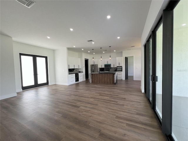 unfurnished living room featuring dark hardwood / wood-style flooring and french doors